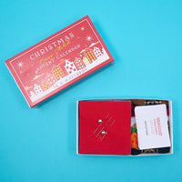 Christmas cross stitch advent calendar with open box on a blue background