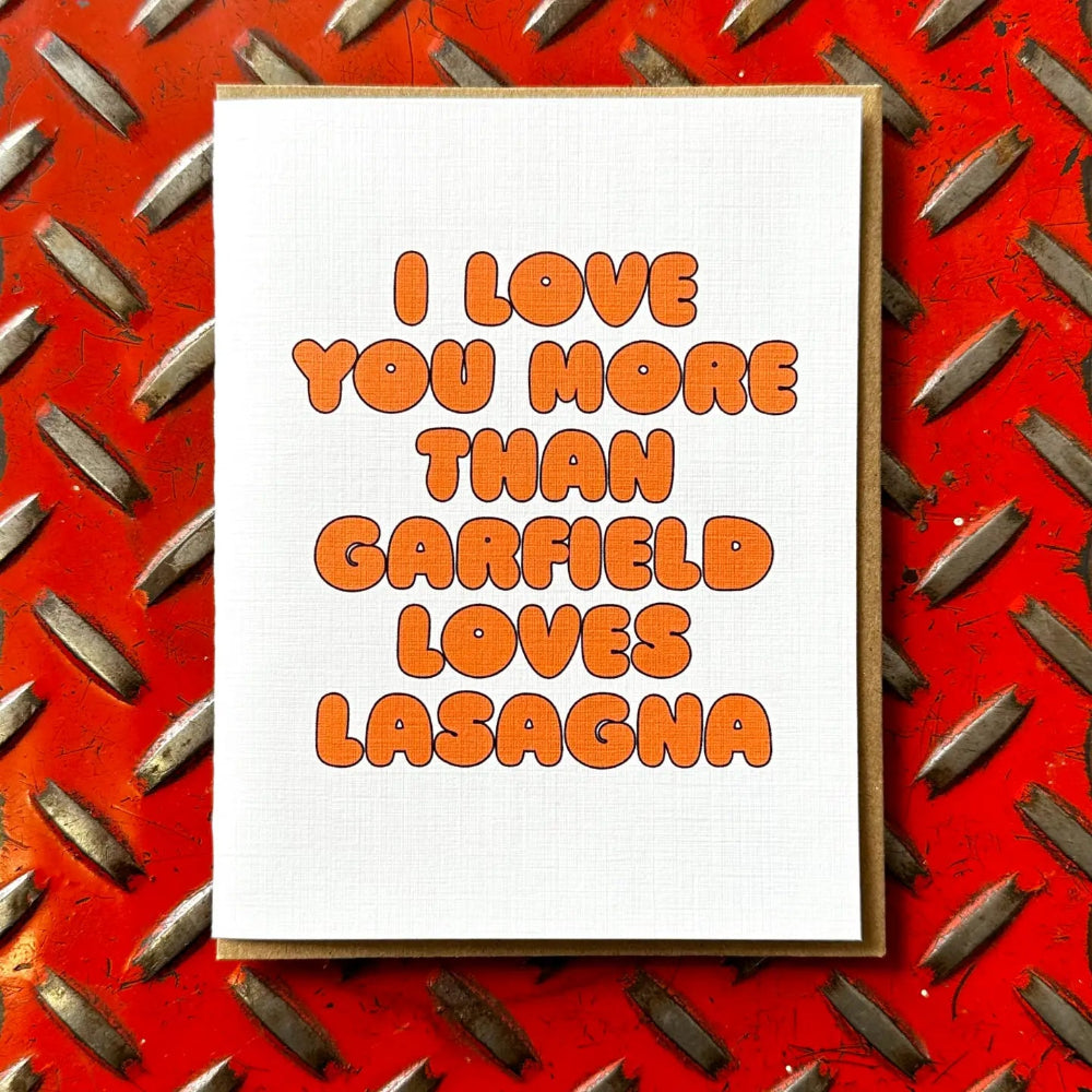 White card with orange lettering saying "I love you more than garfield loves lasagna"