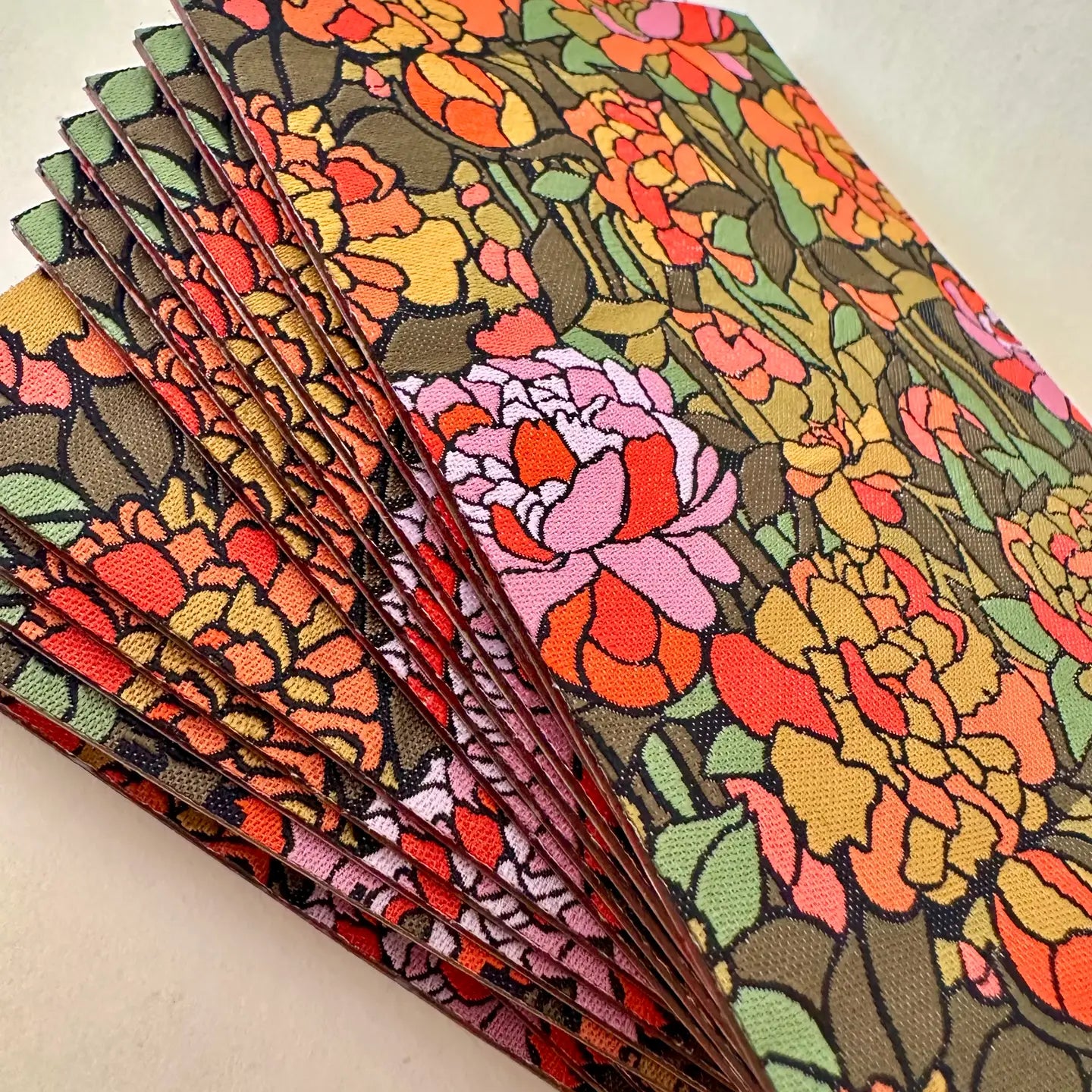 Stack of floral patterned patches on a light background