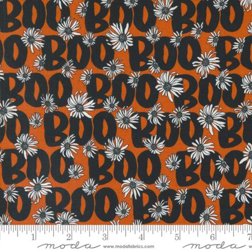 Fabric with 'BOO' text and floral patterns on an orange background, featuring a Moda label.
