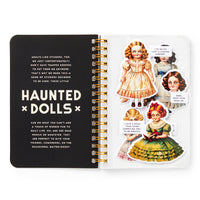 Notebook with 'Haunted Dolls' design on a white background