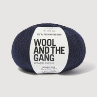 Navy skein of yarn with a 'Wool and the Gang' label on a light gray background