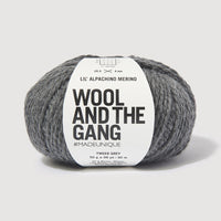 Gray skein of yarn with 'Wool and the Gang' label on a light gray background