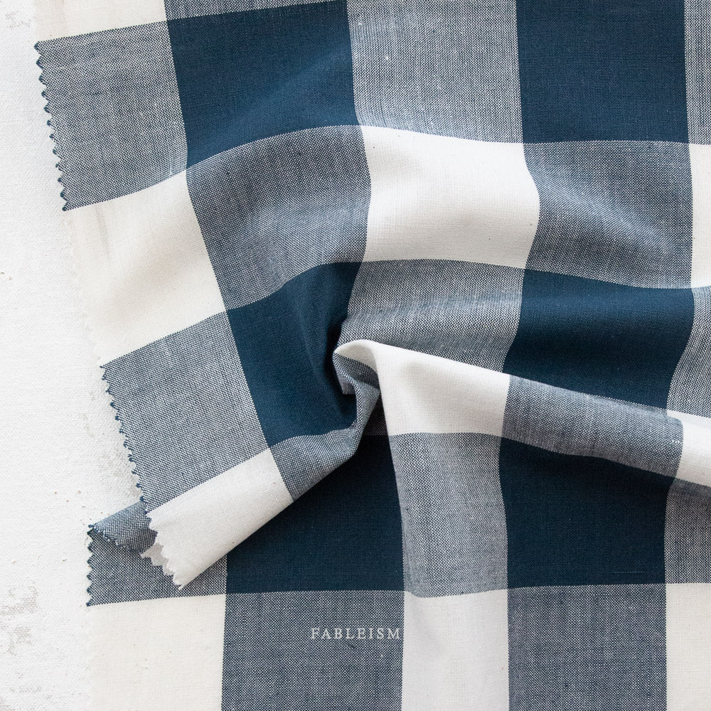 Blue and white checkered fabric with 'Fableism' branding on a light background