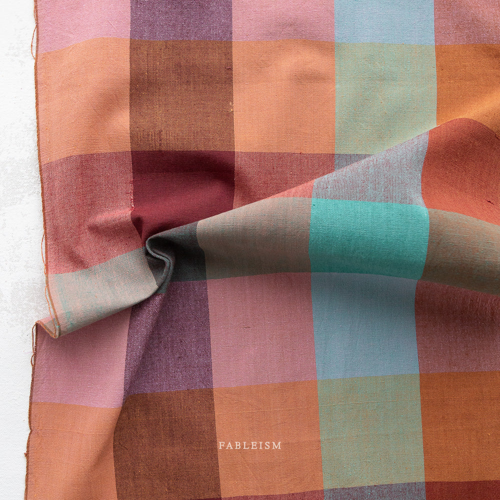 Multicolored checkered fabric with 'Fableism' branding on a white background
