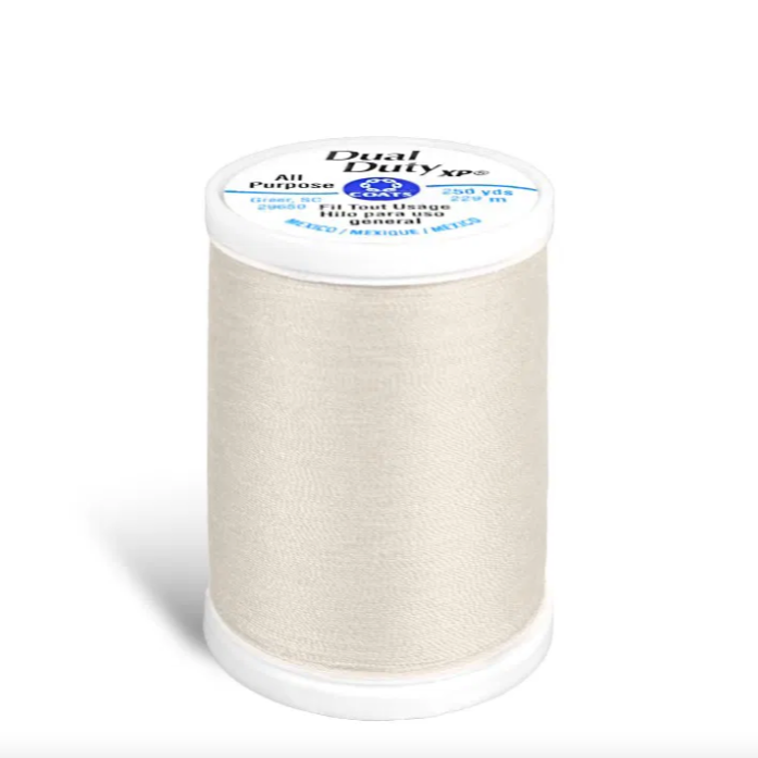 Spool of white thread with a label on a white background