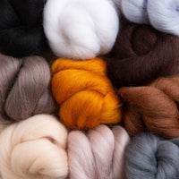 Close up of the roving bundles in white, black, grey, beige, browns and orange.
