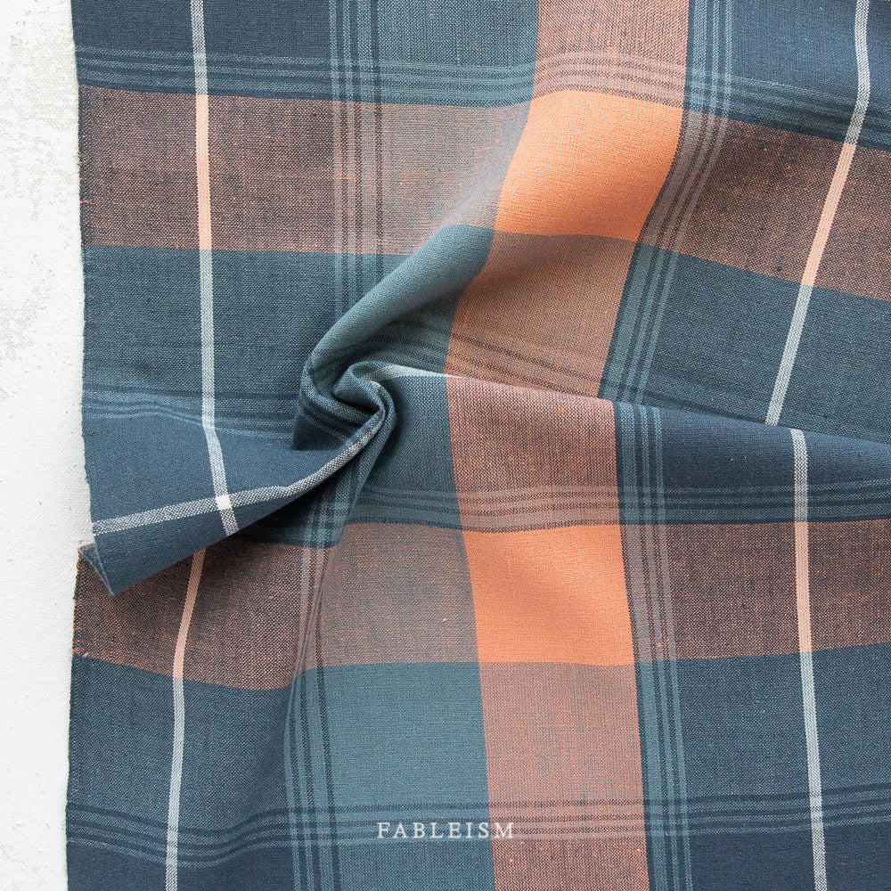 Blue and orange gingham with white lines interwoven on white background with the word Fableism on the bottom