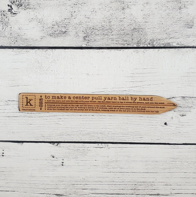 Wood with instructions for hand winding a yarn ball