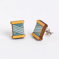 Wooden bobbin earrings on a white background
