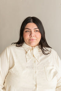 View from the front of a person wearing the long sleeve version of the Butano Button Up in a white fabric.
