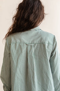 View from the back of a person wearing the long sleeve version of the Butano Button Up in a striped fabric.