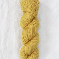 Yellow skein of yarn on a white background