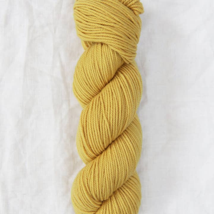 Yellow skein of yarn on a white background