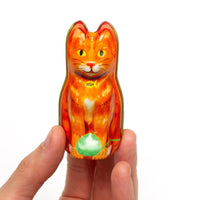 Hand holding a cat tin with stitch markers