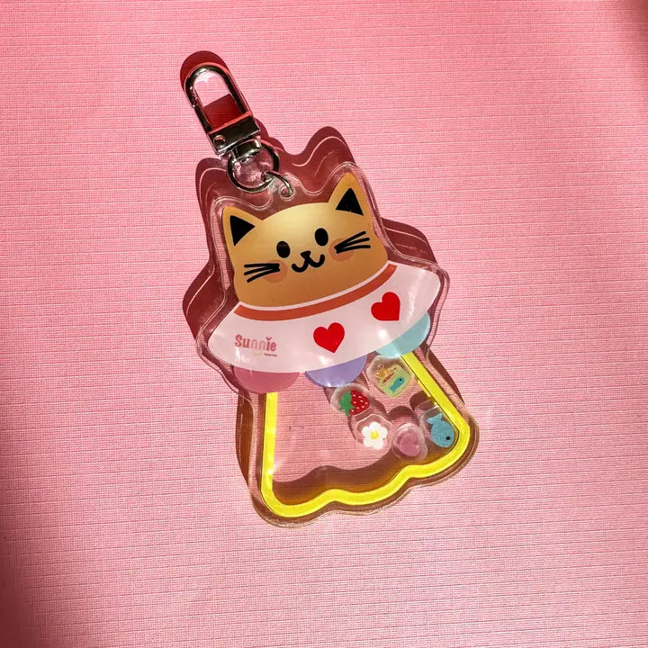 Cat-shaped keychain in the shape of a UFO on a pink background