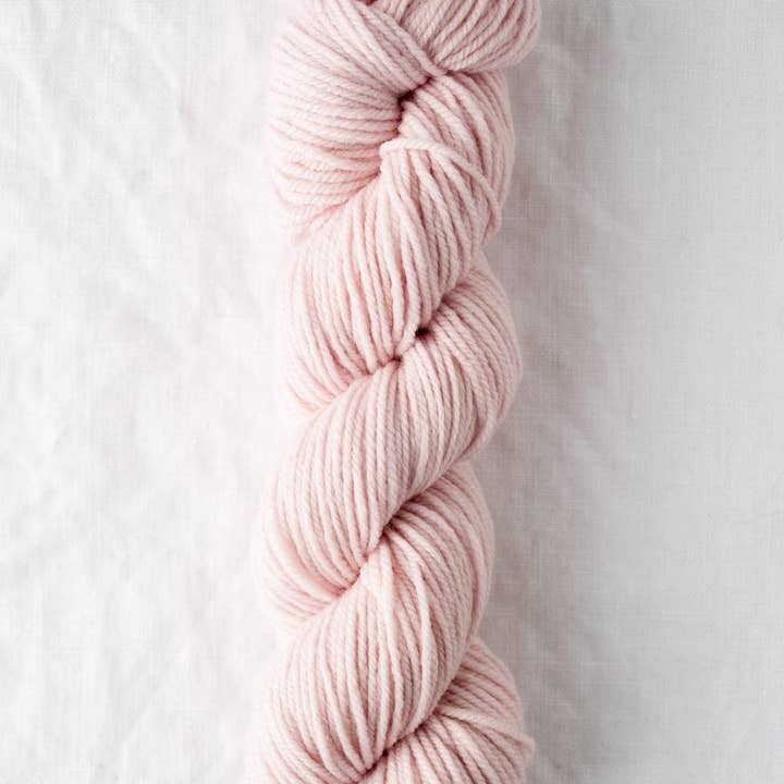 Pink skein of yarn on a light gray background