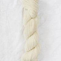 Braided skein of cream-colored yarn on a white background