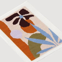 Needlepoint with abstract plant designs on a light gray background