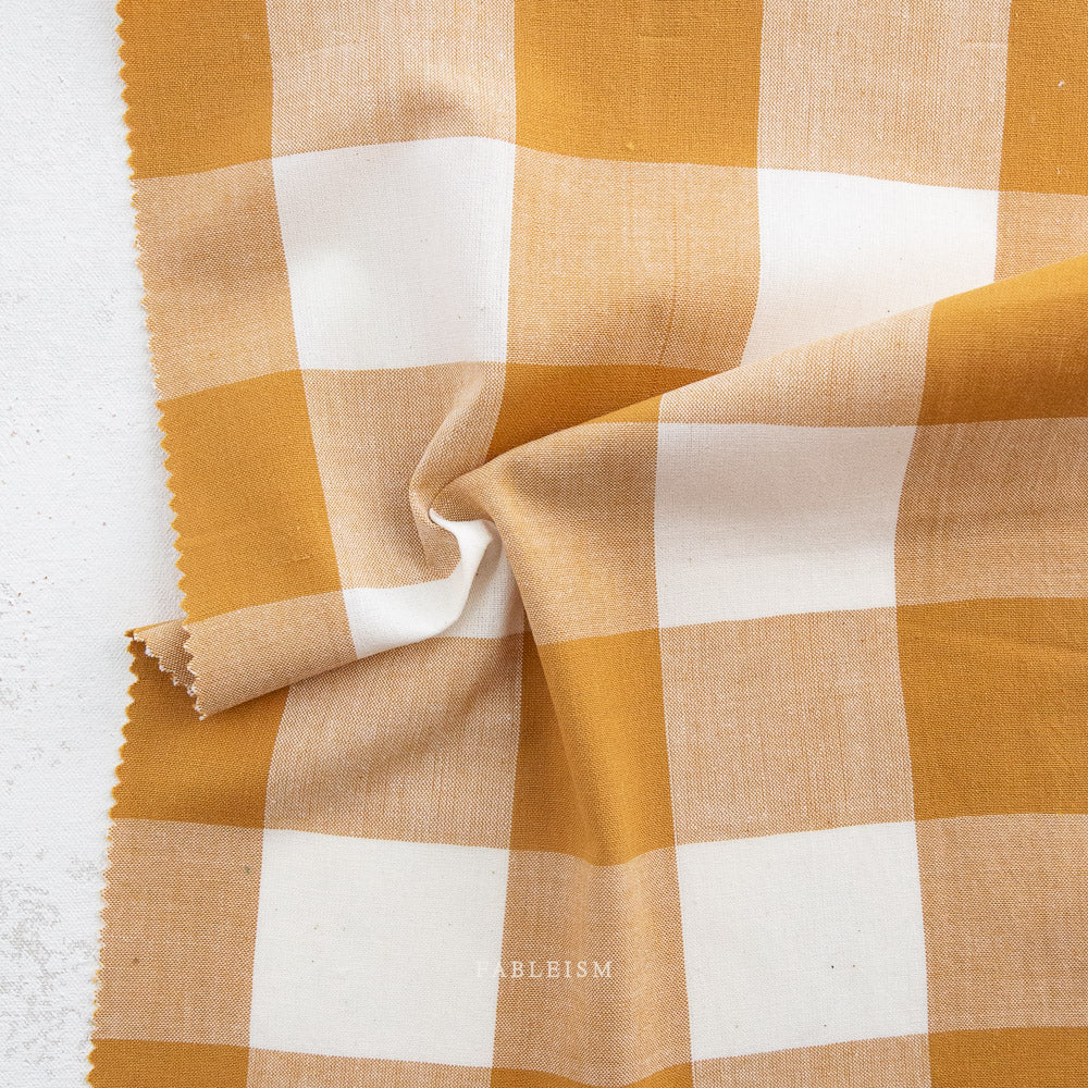Orange and white gingham fabric on a white background
