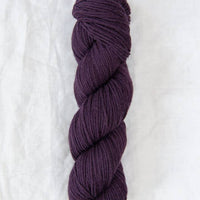 Purple skein of yarn on a white background