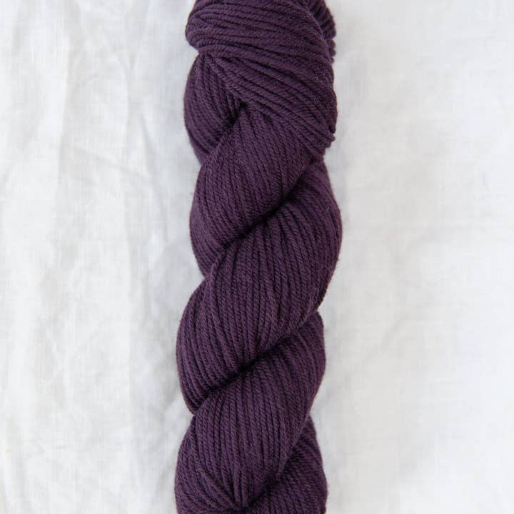 Purple skein of yarn on a white background