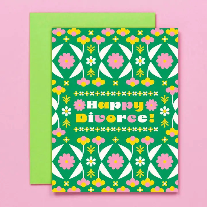 Green greeting card with "Happy Divorce" written on it surround by flowers on a pink background.