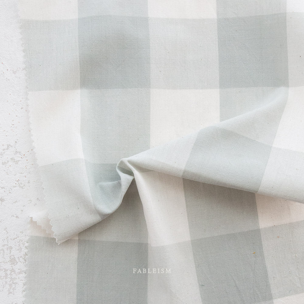 Checkered fabric with a soft texture, featuring shades of green and white.
