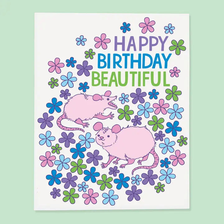 Birthday card with two pink possums and colorful flowers on a light green background