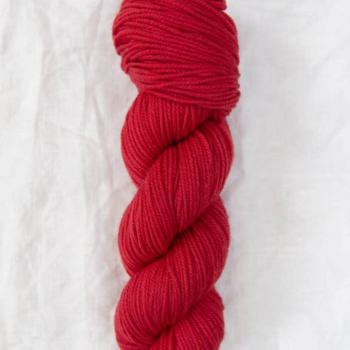 Red skein of yarn on a white background