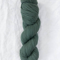 Skein of green yarn on a white background