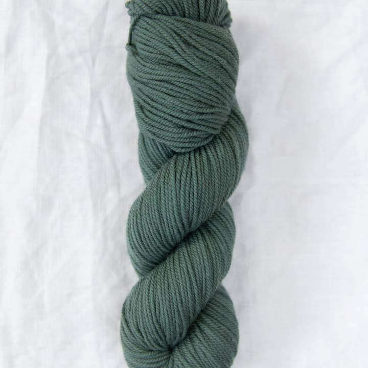 Skein of green yarn on a white background