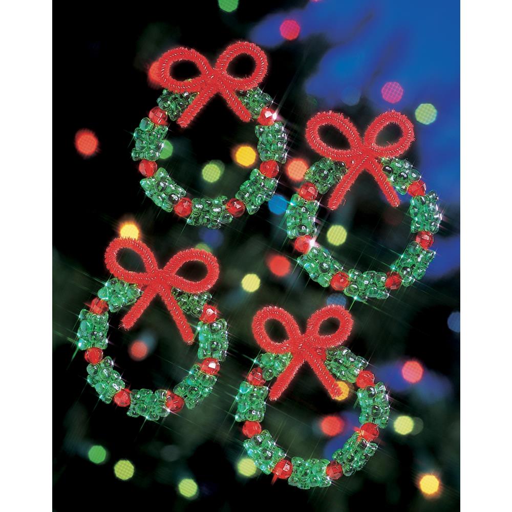 Set of four beaded Christmas wreath decorations with red bows on a blurred festive background.