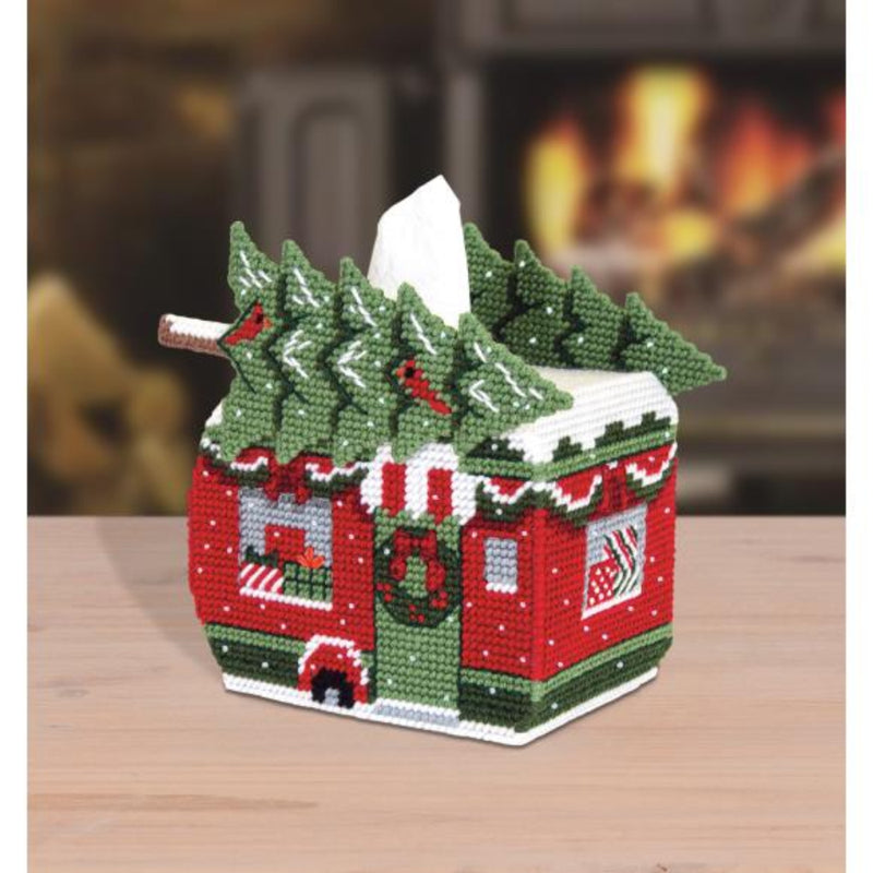 Christmas-themed tissue box cover with trees and a camper design on a wooden surface.