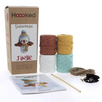 Crochet kit with yarn, hook, and instructions for a snowman-themed project on a white background.