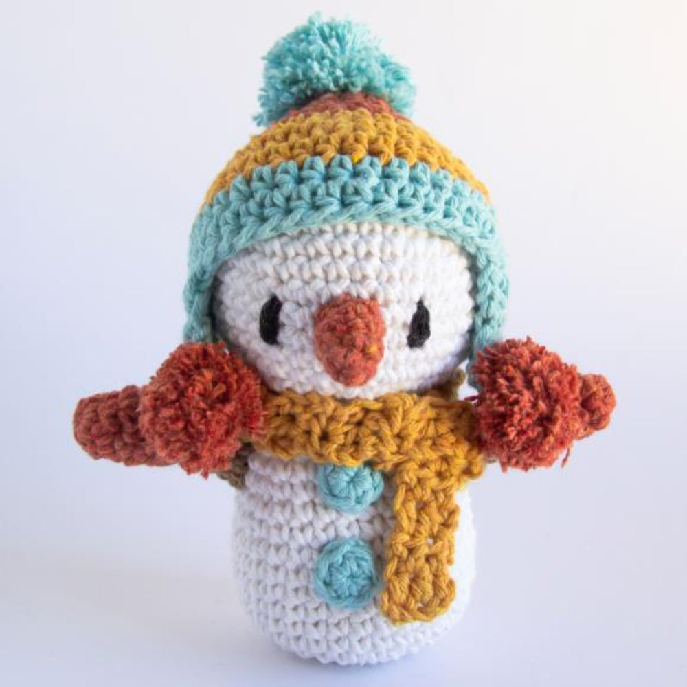 Crocheted snowman toy with a colorful hat and scarf on a white background