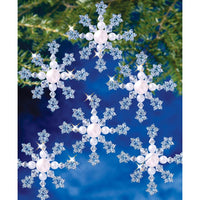 Beaded blue snowflakes with a beaded white center on a blue background. 