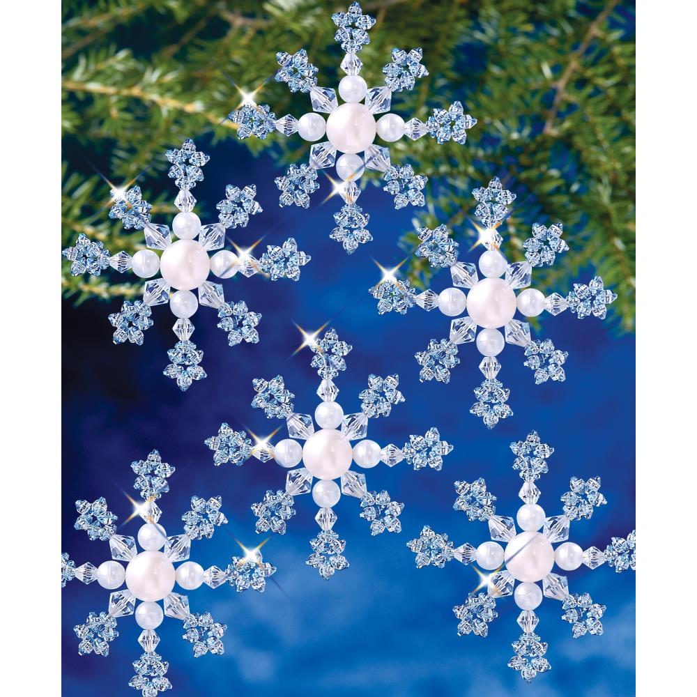 Beaded blue snowflakes with a beaded white center on a blue background. 