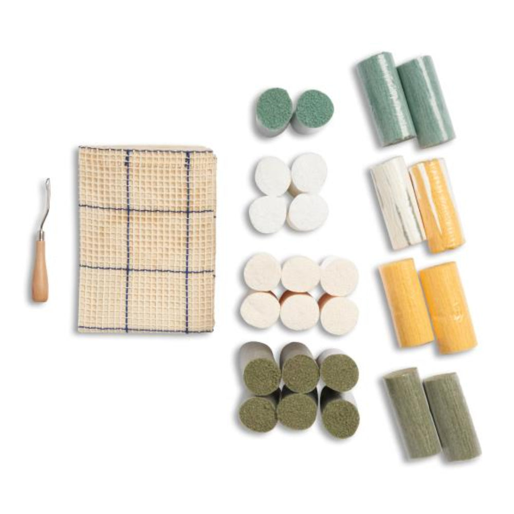 Contents of the kit including canvas, latch hook and yarn on a white background