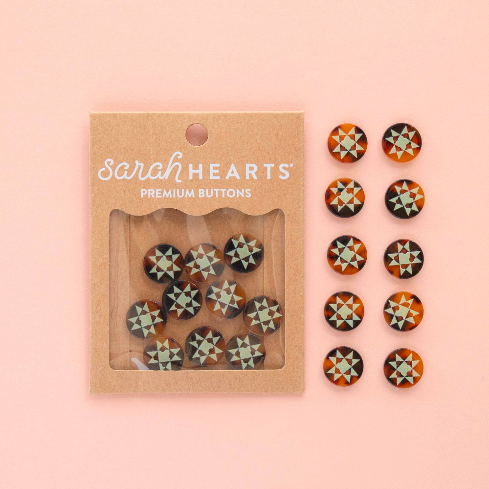 Packaged set of 'Sarah Hearts' premium buttons on a pink background
