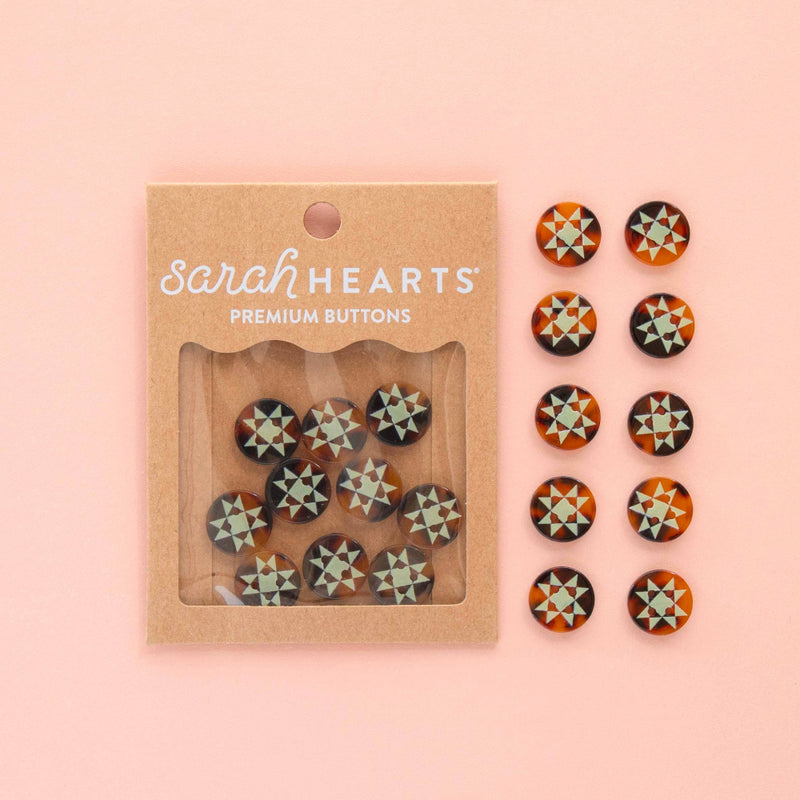 Packaged set of 'Sarah Hearts' premium buttons on a pink background