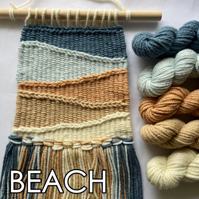 Woven textile with beach-themed color palette and skeins of yarn on a white background