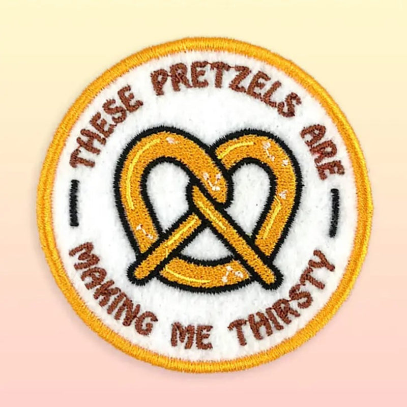 Embroidered patch with pretzels and text on a beige background
