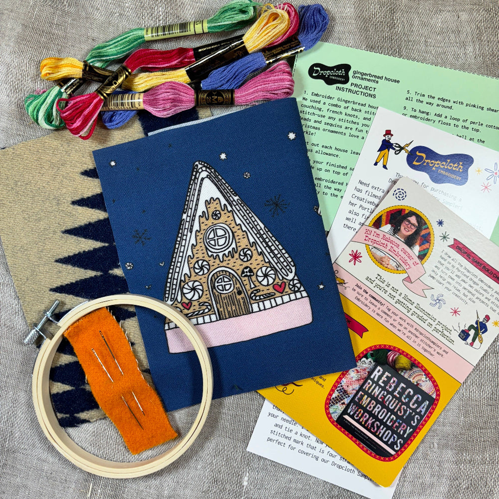 Embroidery kit with materials and instructions on a textured surface