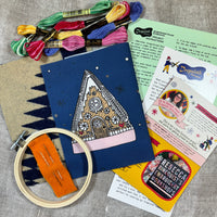 Embroidery kit with materials and instructions on a textured surface