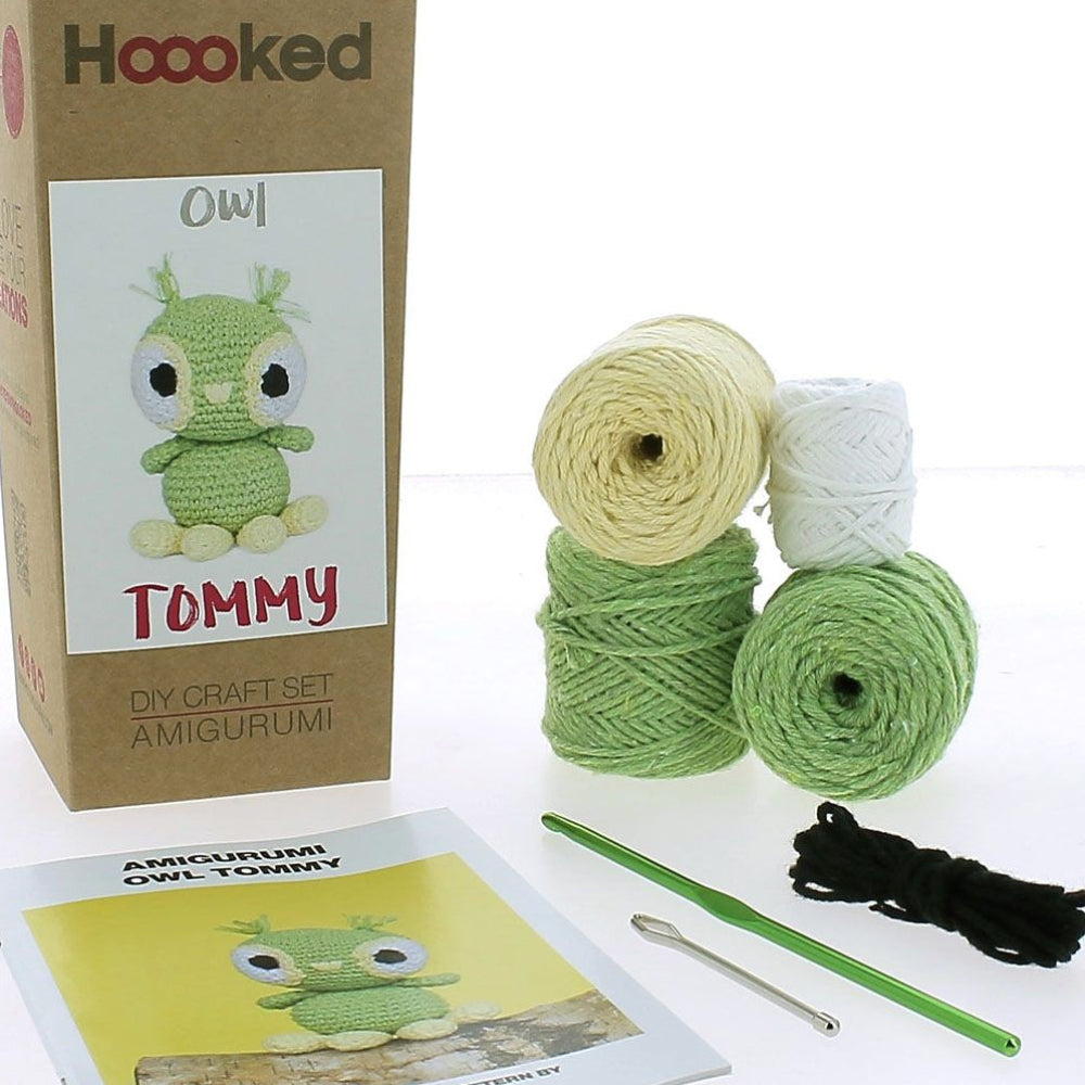 Crochet kit with yarn, hooks, and pattern leaflet on a white background