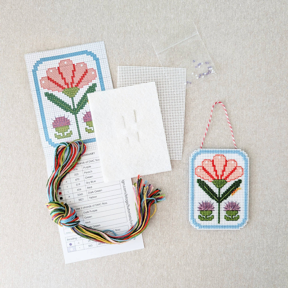 Kit includes beads, canvas, floss, needles, and color printed pattern on a white textured background