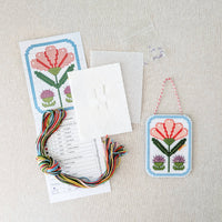 Kit includes beads, canvas, floss, needles, and color printed pattern on a white textured background