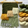 Woven yarn sample with 'FERN' text and skeins of green, yellow, and beige yarn.