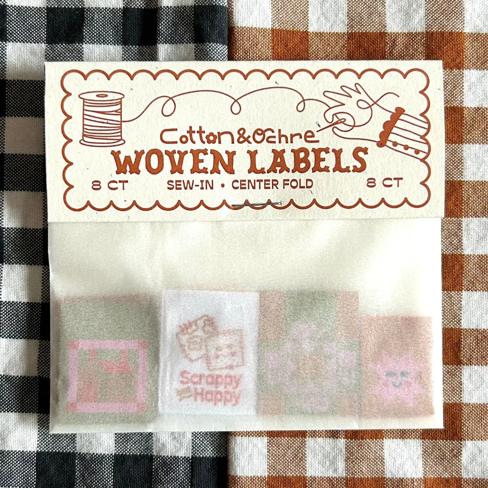 Pack of woven labels with visible designs on a checkered fabric background